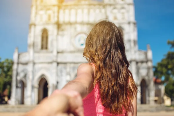 Mulher descobrindo um templo antigo segurando a mão do namorado . — Fotografia de Stock