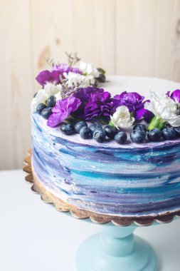 Çok güzel mor çiçekler ve yaban mersini ile renkli düğün pastası