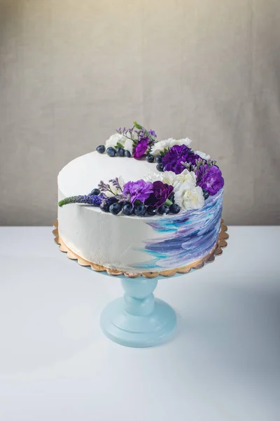 Colorful wedding cake with lovely purple flowers and blueberries — Stock Photo, Image