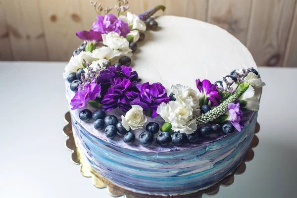 Pastel de boda colorido con hermosas flores púrpura y arándanos — Foto de Stock