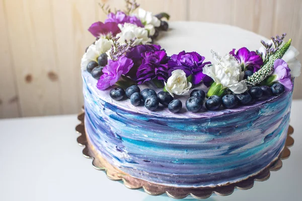 Färgglad bröllopstårta med vackra lila blommor och blåbär — Stockfoto