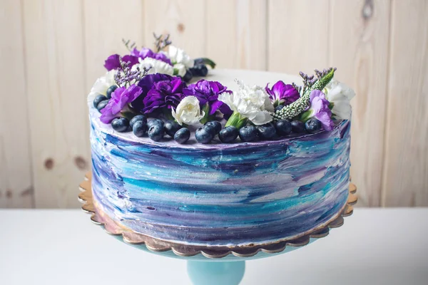 Kolorowy tort weselny z piękne fioletowe kwiaty i jagody — Zdjęcie stockowe