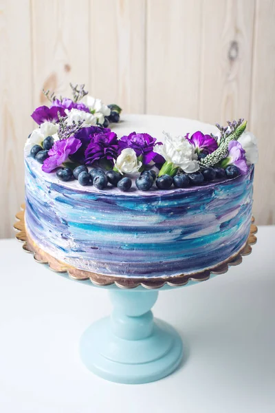 Pastel de boda colorido con hermosas flores púrpura y arándanos —  Fotos de Stock