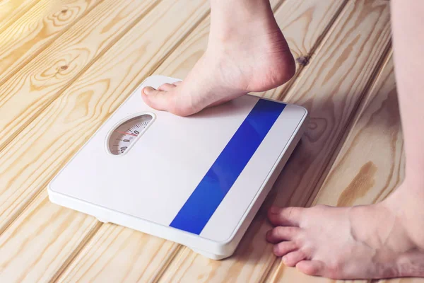 I piedi delle donne sono su bilance meccaniche per il controllo del peso — Foto Stock