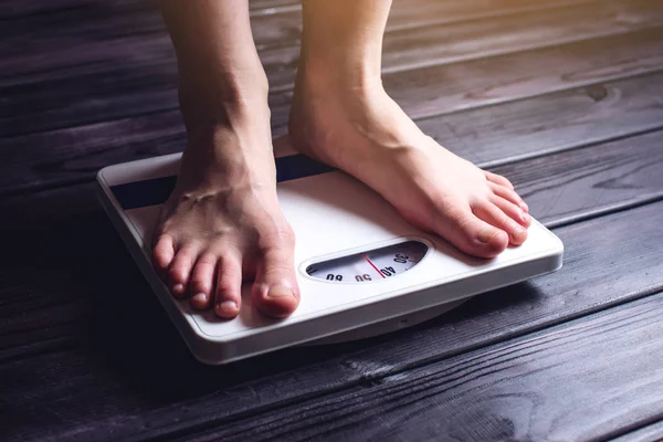 I piedi delle donne sono su bilance meccaniche per il controllo del peso — Foto Stock
