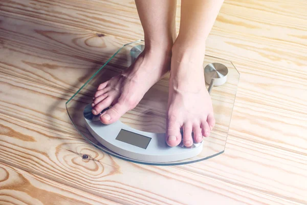 Pés femininos em pé em balanças eletrônicas para controle de peso — Fotografia de Stock
