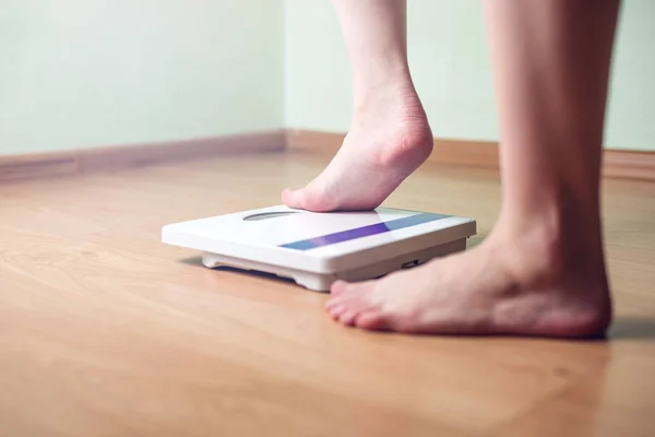 I piedi delle donne sono su bilance meccaniche per il controllo del peso — Foto Stock