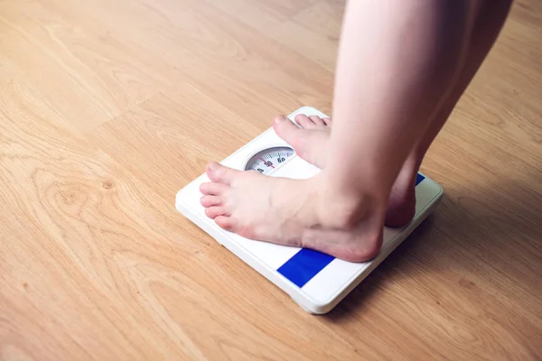 I piedi delle donne sono su bilance meccaniche per il controllo del peso — Foto Stock