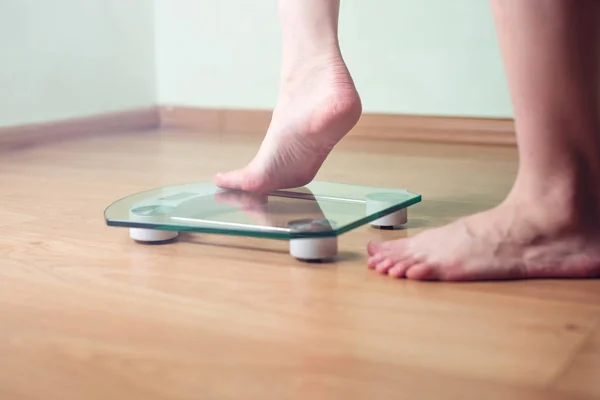 Piedini femminili in piedi su bilance elettroniche per il controllo del peso — Foto Stock