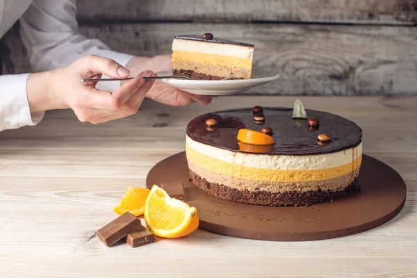 Donna in possesso di pezzo di torta al cioccolato arancione — Foto Stock