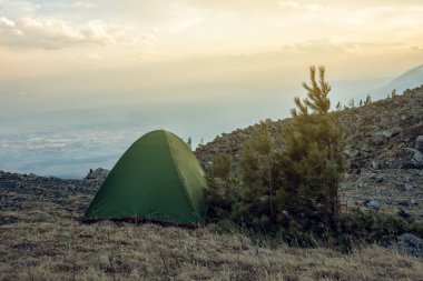 Bahar manzara bakış dağlar ve günbatımında gökyüzünün arka plan üzerinde turist ile çadır