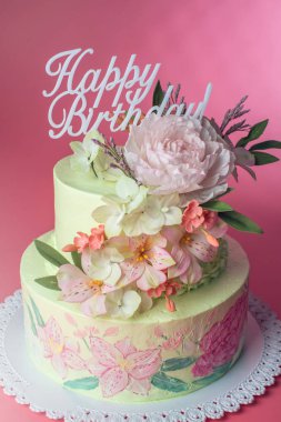 İki katmanlı bir güzel bahar pasta mastik üst ve metinler mutlu yıllar üstüne gül ile dekore edilmiş