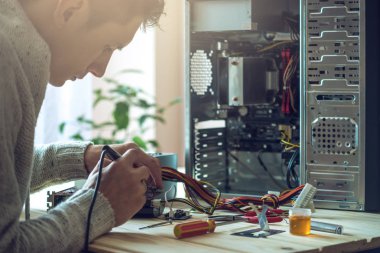 Adam tamirci bir işyeri ofis yeri bilgisayardaki araçları kullanılarak tamir etmeye çalışıyor