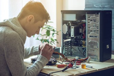 Adam tamirci bir işyeri ofis yeri bilgisayardaki araçları kullanılarak tamir etmeye çalışıyor