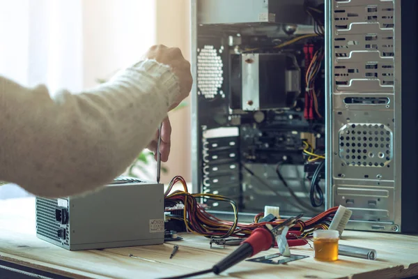 Επισκευαστή ο άνθρωπος προσπαθεί να διορθώσετε χρησιμοποιώντας τα εργαλεία στον υπολογιστή που βρίσκεται σε ένα χώρο εργασίας στο γραφείο — Φωτογραφία Αρχείου