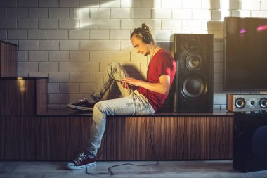 Yakışıklı, bir müzik aşığı bir cep telefonu medya ve büyük hoparlörler kulaklık ile müzik dinler.