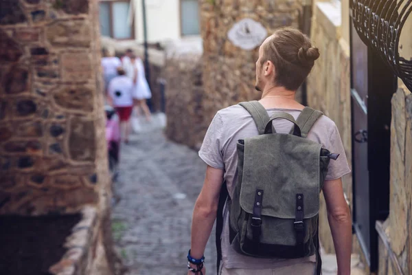 Homem viajante com mochila explorar a aldeia andando nas ruas antigas e explorar os castelos e fortalezas — Fotografia de Stock