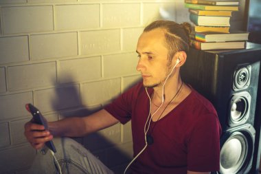 Kulaklık Ses Kaseti dinlerken çekici bir genç adam. Teknoloji eğitimi olumlu bir yaşam tarzı kavramı