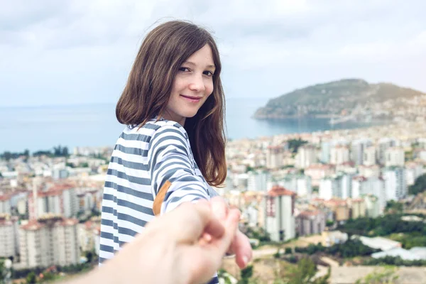 Siga-me, menina morena atraente segurando a mão leva para a cidade costeira de uma altura — Fotografia de Stock