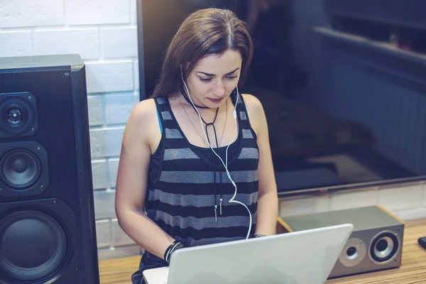 Dziewczyna z słuchawki słuchanie lekcji lub książki audio w telefonie i pracę na laptopie. Koncepcja edukacji technologii — Zdjęcie stockowe