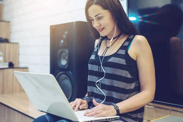 Dziewczyna z słuchawki słuchanie lekcji lub książki audio w telefonie i pracę na laptopie. Koncepcja edukacji technologii — Zdjęcie stockowe