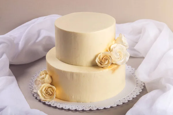 Beige 2 torta nuziale a più livelli decorato con rose mastice stand su sfondo tessuto — Foto Stock