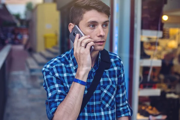 Человек путешественник с рюкзаком разговаривает по телефону на заднем плане улицы . — стоковое фото