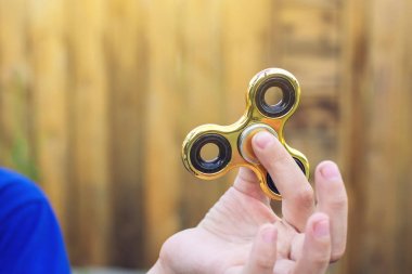 Bir çocuk elini açık havada üzerinde büküm spinner çalış. Çocukların anti-stres oyuncakları eğilimler