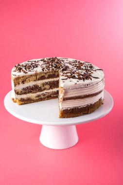İzole ev yapımı katmanlı sünger kek parçası pembe bir arka plan üzerinde dışarı kesim ile rustik tarzda beyaz krema ile