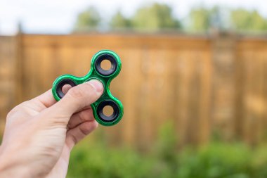 Bir çocuk elini açık havada üzerinde büküm spinner çalış. Çocukların anti-stres oyuncakları eğilimler