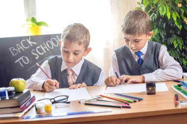 Okula dönüş. Şirin çocuk sınıfta masasında oturuyor. Çocuklar ders öğrenme. Kavram İlköğretim Okulu