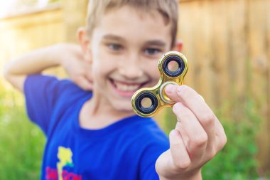 Bir çocuk elini açık havada üzerinde büküm spinner çalış. Çocukların anti-stres oyuncakları eğilimler