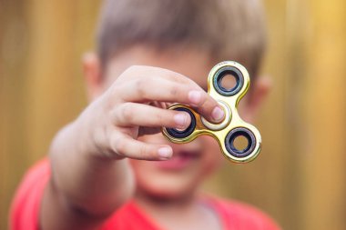 Bir çocuk elini açık havada üzerinde büküm spinner çalış. Çocukların anti-stres oyuncakları eğilimler