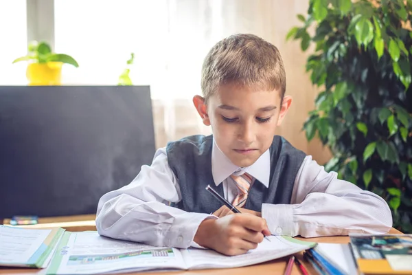 Okula dönüş. Şirin çocuk sınıfta masasında oturuyor. Çocuk dersleri öğreniyor. Kavram İlköğretim Okulu