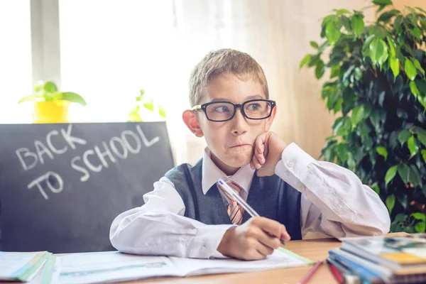 Okula dönüş. Şirin çocuk sınıfta masasında oturuyor. Çocuk dersleri öğreniyor. Kavram İlköğretim Okulu