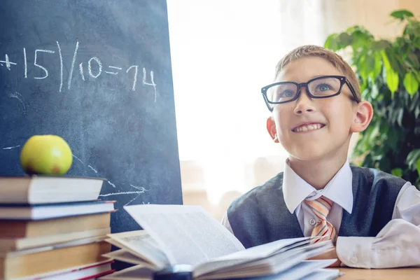 Okula dönüş. Akıllı çocuk sınıfta bir görev çözer. Çocuk tahtaya yazıyor. Kavram İlköğretim Okulu