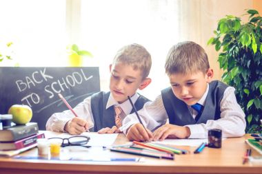 Okula dönüş. Şirin çocuk sınıfta masasında oturuyor. Çocuklar ders öğrenme. Kavram İlköğretim Okulu