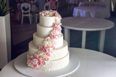 Pembe Gül'de Restoran tabloda süslenmiş büyük katmanlı düğün pastası