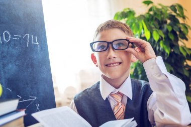 Okula dönüş. Şirin çocuk sınıfta masasında oturuyor. Kavram İlköğretim Okulu