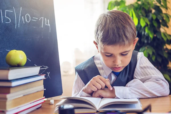 Zurück zur Schule. Nettes Kind, das am Schreibtisch im Klassenzimmer sitzt. Junge zieht Lehren. Konzept Grundschule — Stockfoto