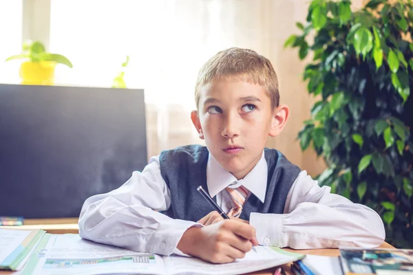 Vissza az iskolába. Aranyos gyerek ül a tanteremben a íróasztal. Fiú a tanulságok. Koncepció általános iskola — Stock Fotó