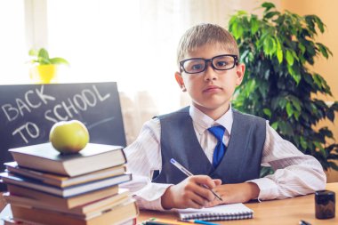 Okula dönüş. Şirin çocuk sınıfta masasında oturuyor. Çocuk dersleri öğreniyor. Kavram İlköğretim Okulu