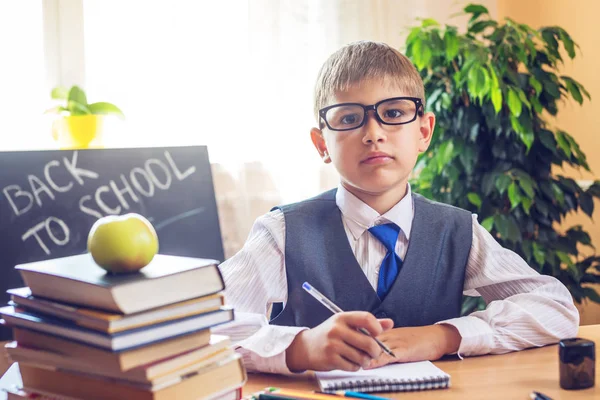 Zurück zur Schule. Nettes Kind, das am Schreibtisch im Klassenzimmer sitzt. Junge zieht Lehren. Konzept Grundschule — Stockfoto