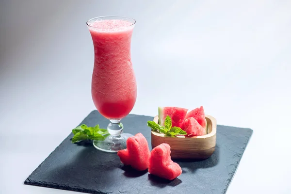 Frisk rød smoothie i et glas med skiver af vandmelon og mynte på hvid isoleret baggrund. Sommer kølige drikkevarer - Stock-foto