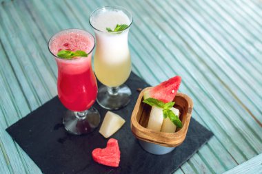 Taze yüzlü mavi zemin üzerine nane ile kavun ve karpuz dilimli adet bir cam içinde. Yaz soğuk içecekler