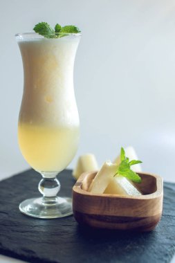 Kavun ve beyaz izole zemin üzerine nane dilimlenmiş parçaları ile bir bardak taze beyaz yüzlü. Yaz soğuk içecekler