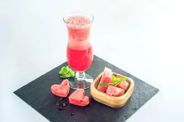 Batido rojo fresco en un vaso con trozos de sandía en rodajas y menta sobre fondo blanco aislado. Bebidas frescas de verano — Foto de Stock