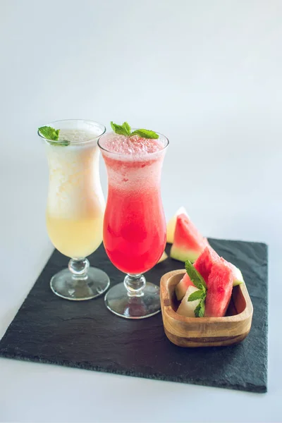 Čerstvé smoothie skla s nakrájené kousky melounu a meloun s mátou na bílém pozadí izolované. Letní nápoje — Stock fotografie