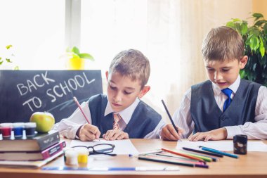 Okula dönüş. Şirin çocuk sınıfta masasında oturuyor. Çocuklar ders öğrenme. Kavram İlköğretim Okulu