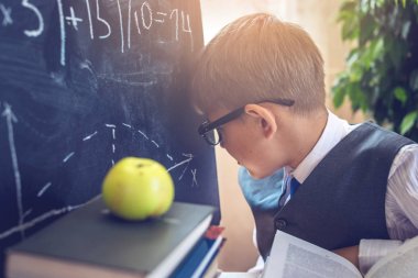 Okula dönüş. Akıllı çocuk sınıfta bir görev çözer. Kavram İlköğretim Okulu